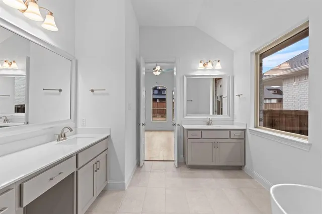 a spacious bathroom with a granite countertop sink mirror and bathtub
