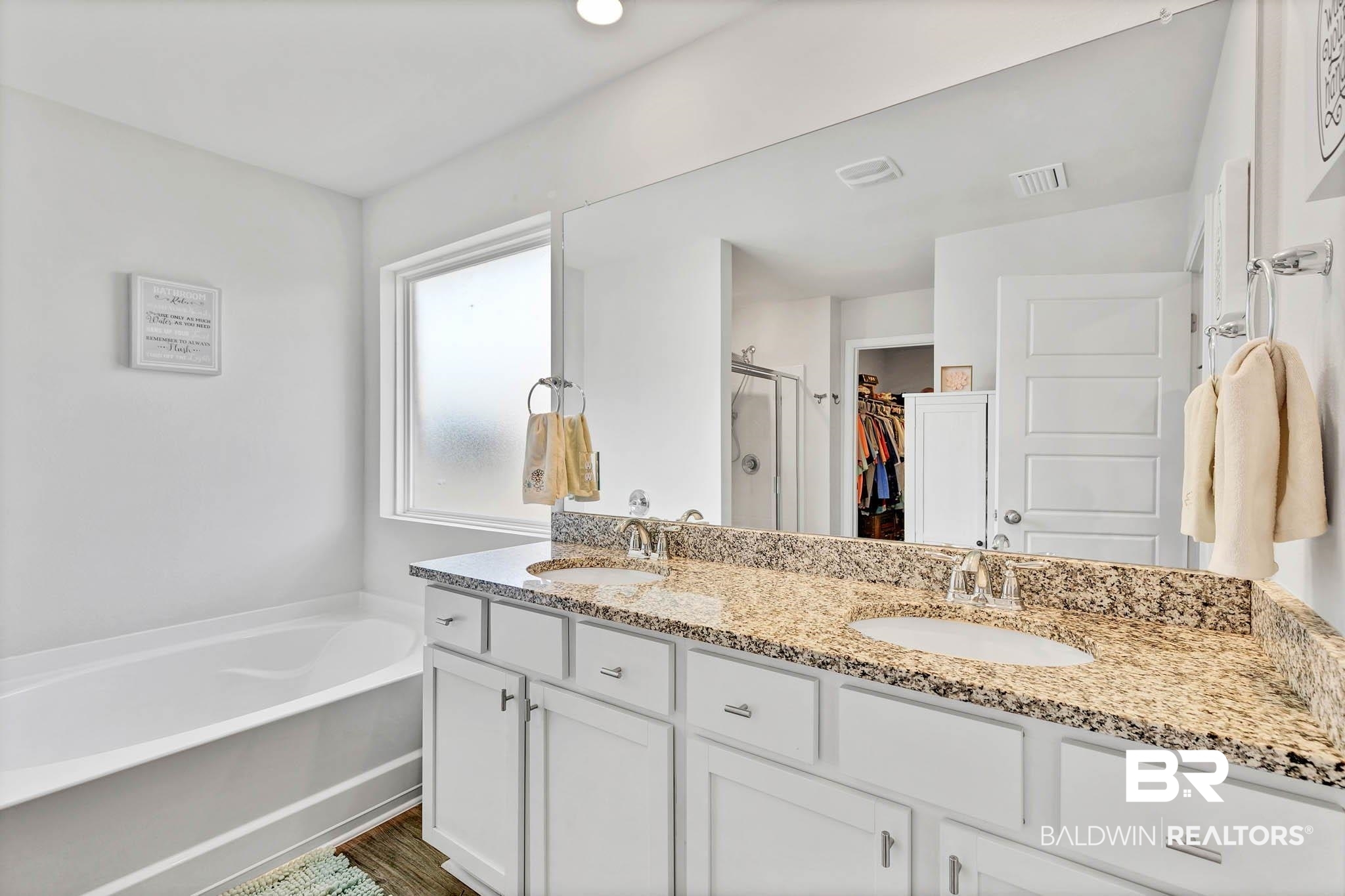 17217 REFLECTION Street Loxley, AL 36551 - Photo 24 of 83 Primary En Suite Bathroom featuring a spacious closet, double vanity, a garden tub, a stall shower, and lvp flooring.