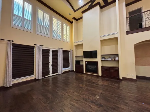a view of a big room with wooden floor and windows