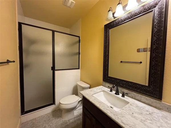 a bathroom with a granite countertop sink toilet and shower