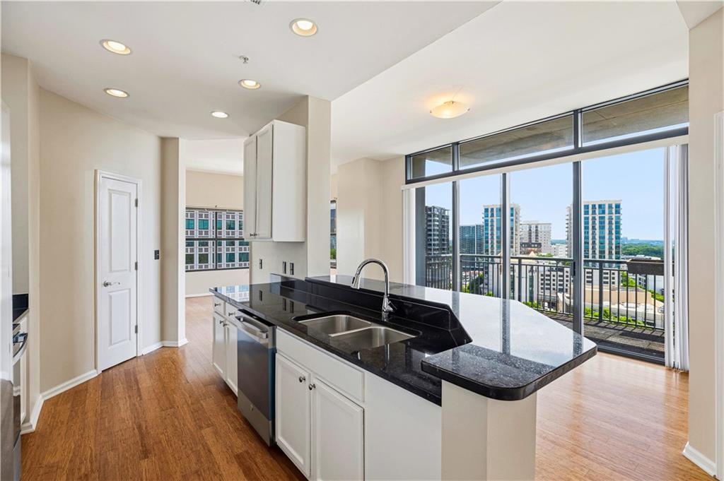 3040 Peachtree Road Northwest, Unit 1503 Atlanta, GA 30305 - Photo 6 of 38 a kitchen with granite countertop a sink and a refrigerator