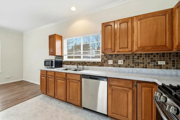 a kitchen with granite countertop wooden cabinets a sink and dishwasher
