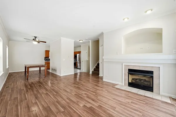 a view of a livingroom with wooden floor and a fireplace