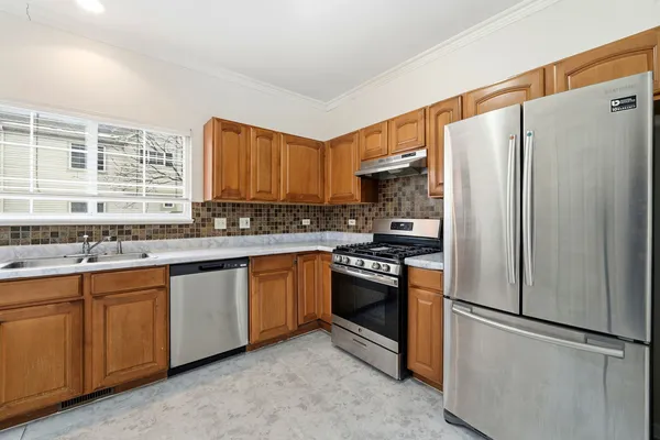 a kitchen with stainless steel appliances granite countertop a refrigerator sink and stove