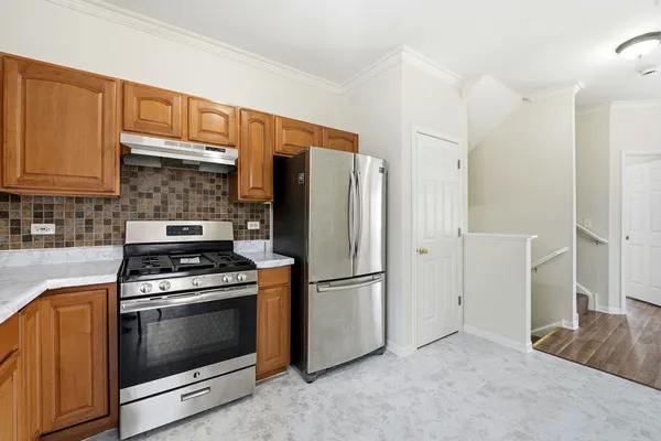 a kitchen with stainless steel appliances granite countertop a refrigerator stove and sink