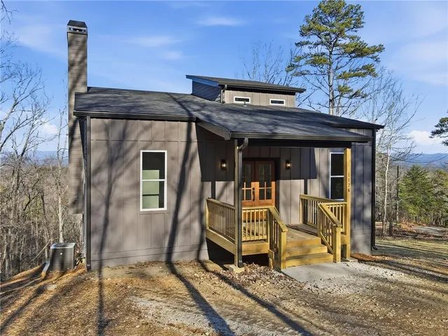 a view of a house with a large window and wooden fence