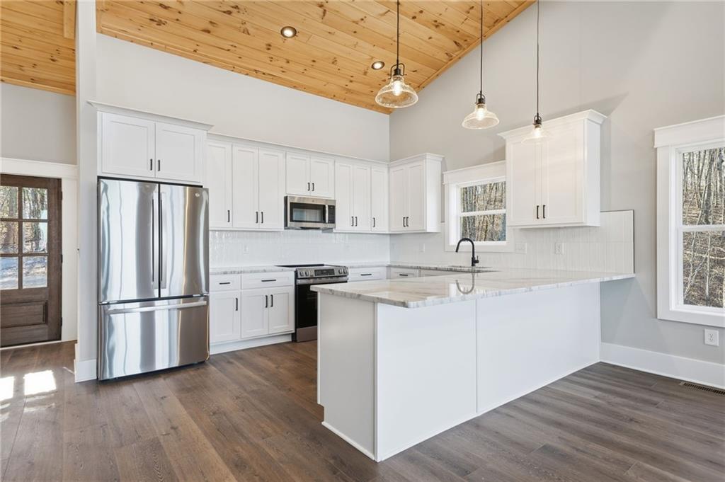 1176 Jewel Court Northeast Ranger, GA 30734 - Photo 13 of 58 a kitchen with stainless steel appliances granite countertop a refrigerator a sink dishwasher a stove and white countertops with wooden floor