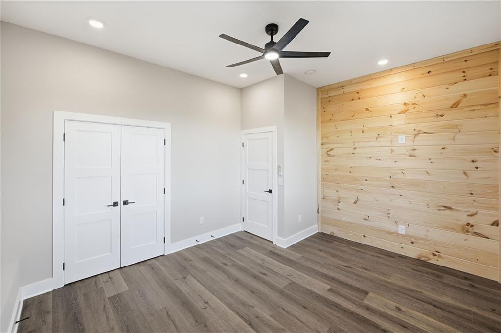 1176 Jewel Court Northeast Ranger, GA 30734 - Photo 40 of 58 an empty room with wooden floor and a ceiling fan