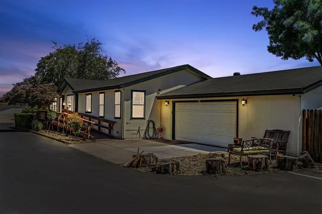 a view of a house with a small yard and wooden fence