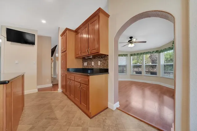 an empty room with windows and a ceiling fan