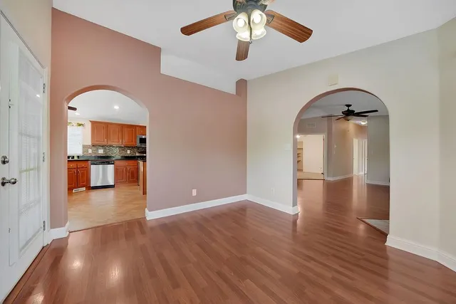 an empty room with a fan and a chandelier fan