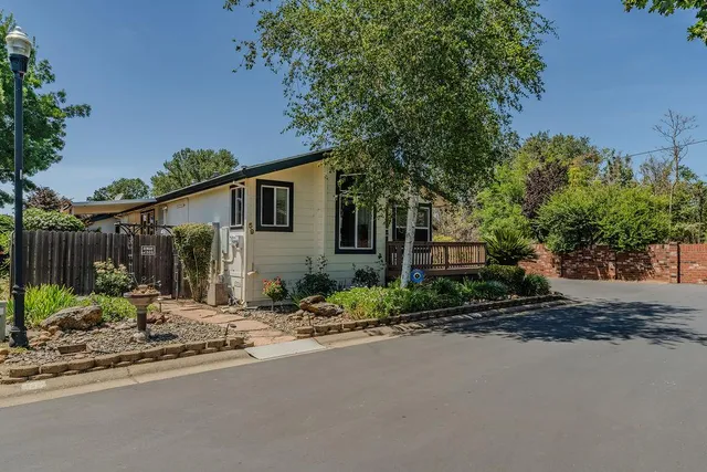 a view of a house with a yard and large trees
