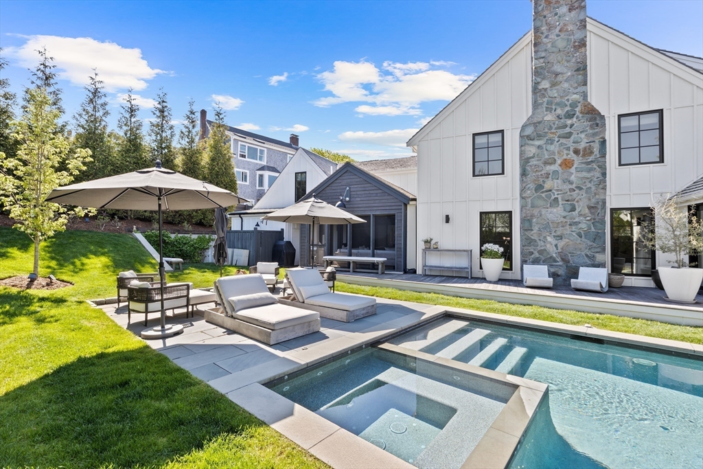 178 Otis Street Hingham, MA 02043 - Photo 37 of 41 a view of a swimming pool with lawn chairs under an umbrella