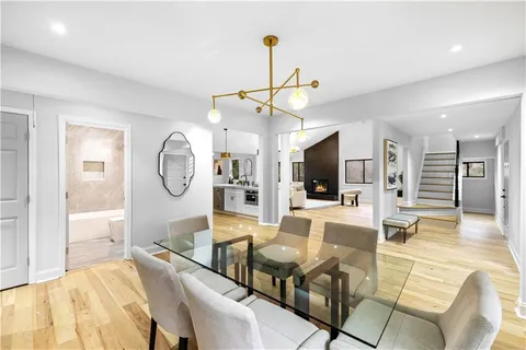a living room with furniture a flat screen tv and kitchen view