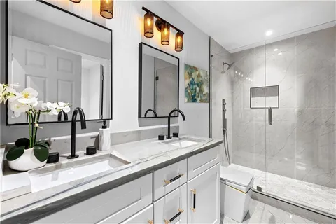 a bathroom with double vanity and a mirror