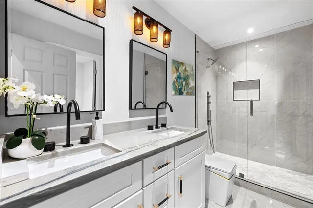 a bathroom with double vanity and a mirror