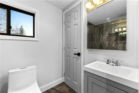 a bathroom with a toilet a sink and mirror