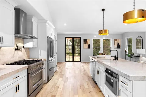 a kitchen with stainless steel appliances a stove a sink and a wooden floors