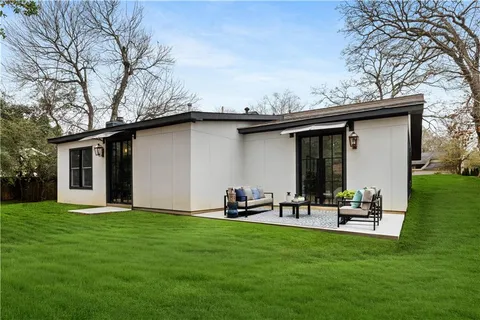 a backyard of a house with table and chairs