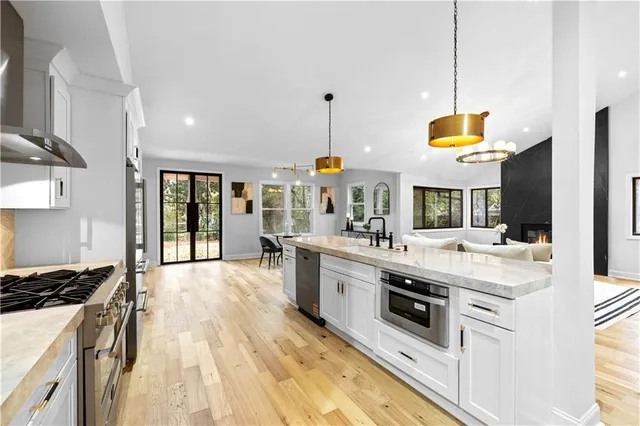 a large kitchen with stainless steel appliances granite countertop a stove and a sink
