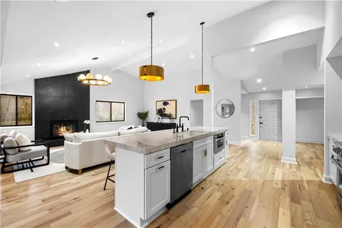 a large kitchen with kitchen island a large counter space a sink a window and stainless steel appliances