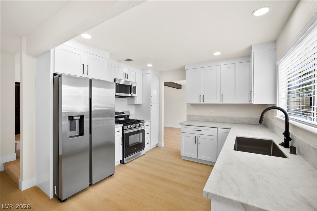 2411 Doherty Way Henderson, NV 89014 - Photo 8 of 34 Culinary delights await in this bright kitchen, featuring clean lines and durable surfaces.