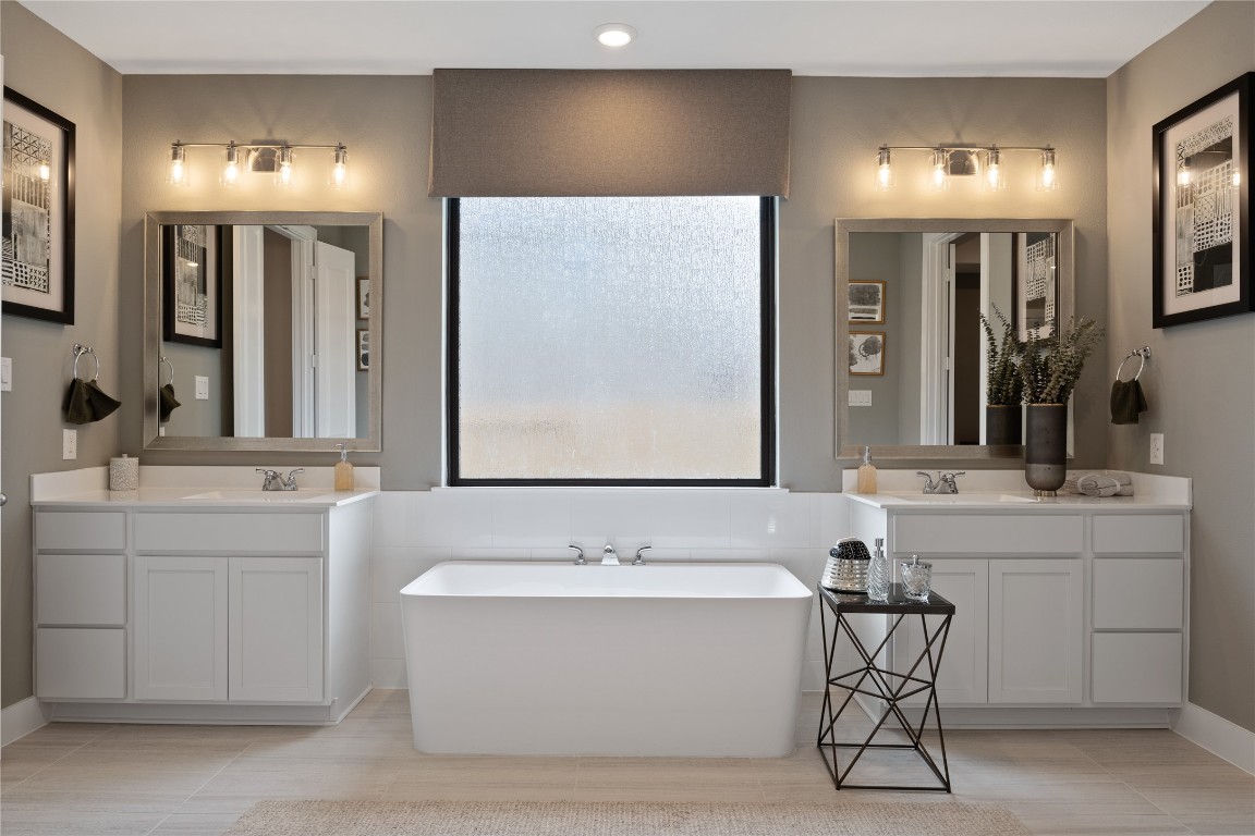 813 Green Ash Way Waller, TX 77484 - Photo 22 of 41 a bathroom with a bathtub a double vanity sink and a mirror