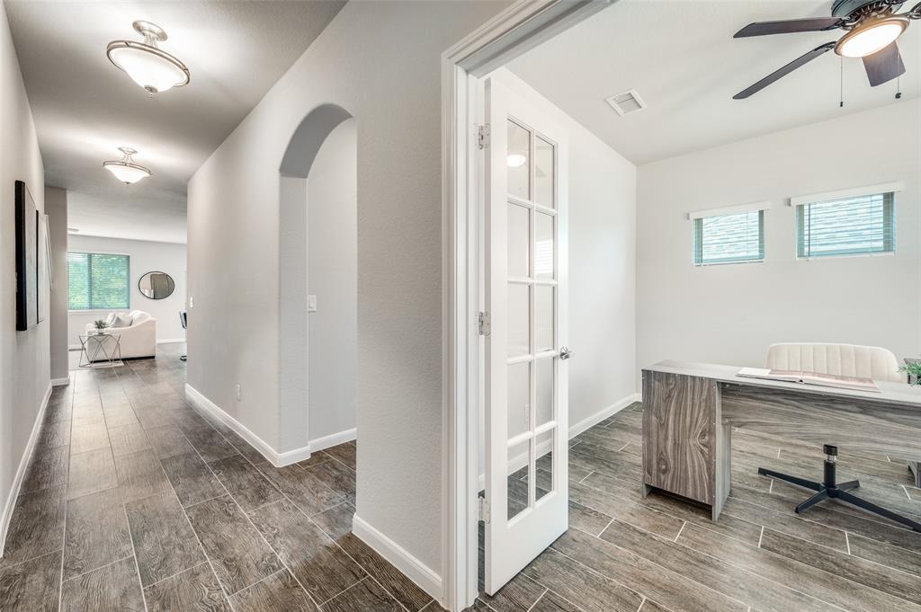 1240 Morning Ridge Trail Aubrey, TX 76227 - Photo 2 of 25 Home office featuring plenty of natural light, wood finish floors, a ceiling fan, and arched walkways
