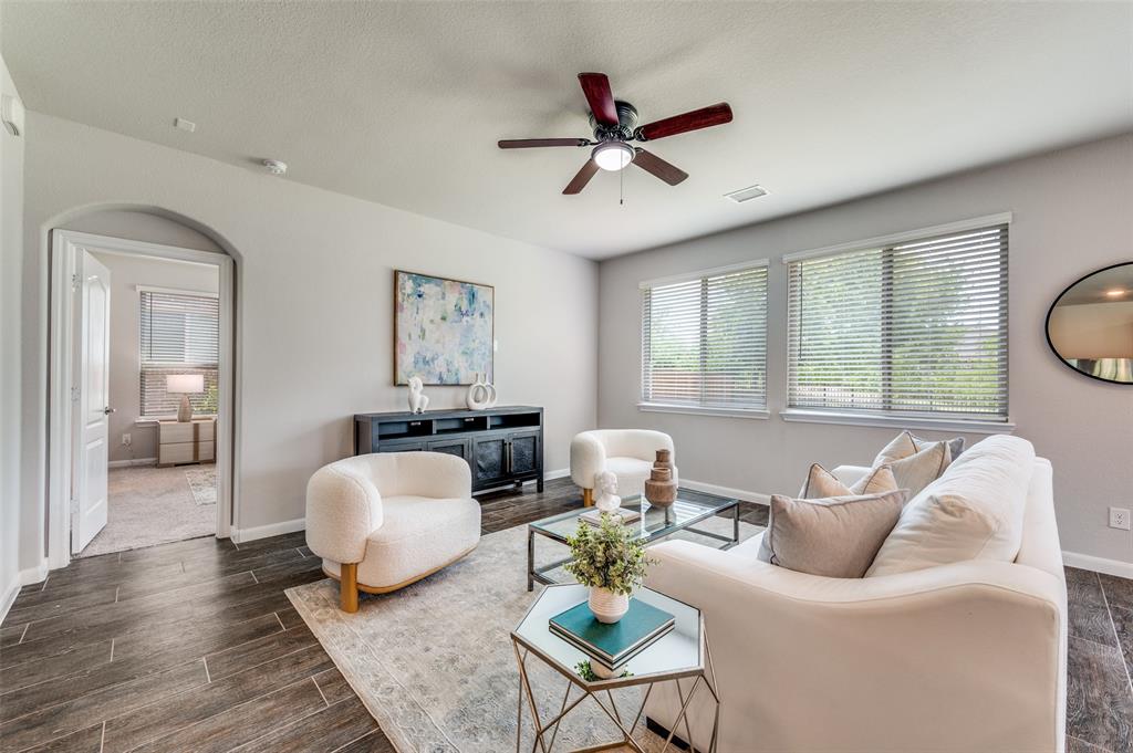 1240 Morning Ridge Trail Aubrey, TX 76227 - Photo 5 of 25 Living area with dark wood finished floors, ceiling fan, and arched walkways