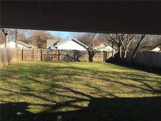 a view of a big yard with table and chairs under an umbrella