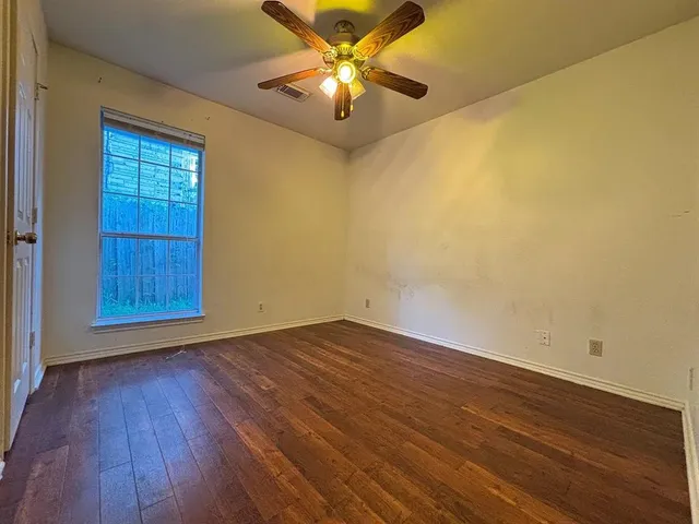 a view of an empty room and window and wooden floor
