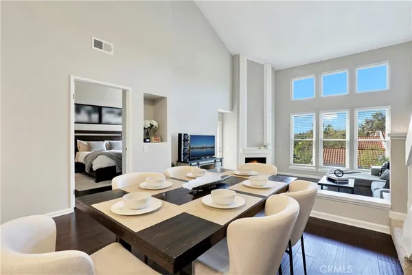 a dining room with furniture a large window and a chandelier