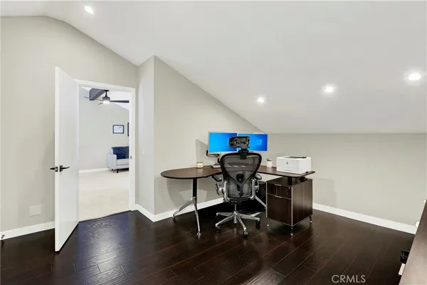 a view of a workspace with furniture and wooden floor