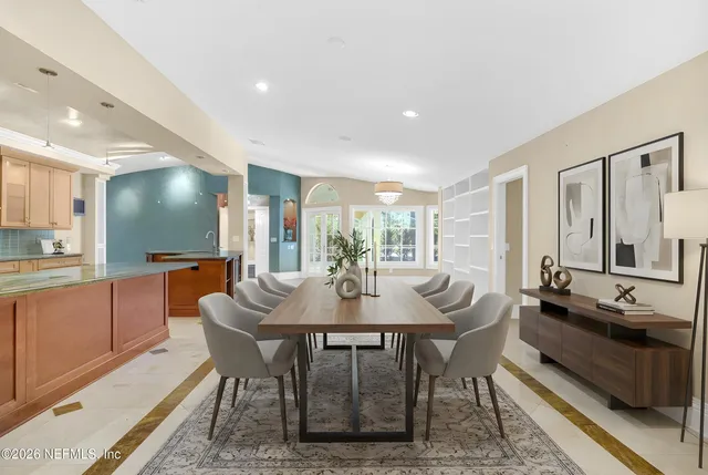 a dining room with furniture a chandelier and wooden floor