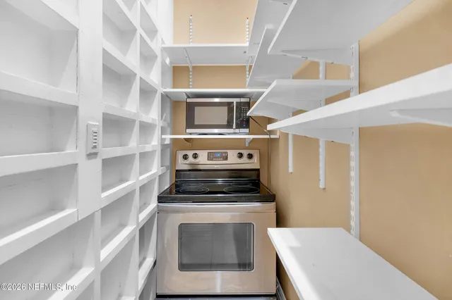 a view of a hallway with a livingroom and a bathroom with sink