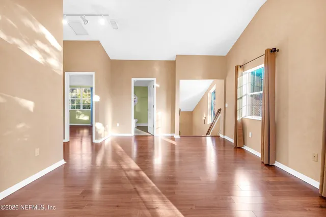 an empty room with wooden stairs and deck