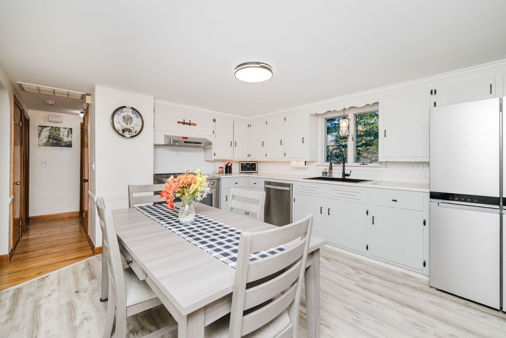 185 Moulton Street Rehoboth, MA 02769 - Photo 8 of 40 a kitchen with a stove a refrigerator and a dining table