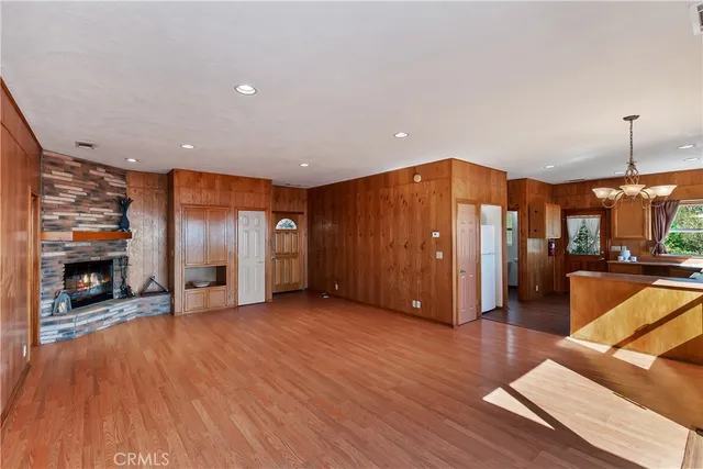 a view of a livingroom with furniture fire place and an empty room
