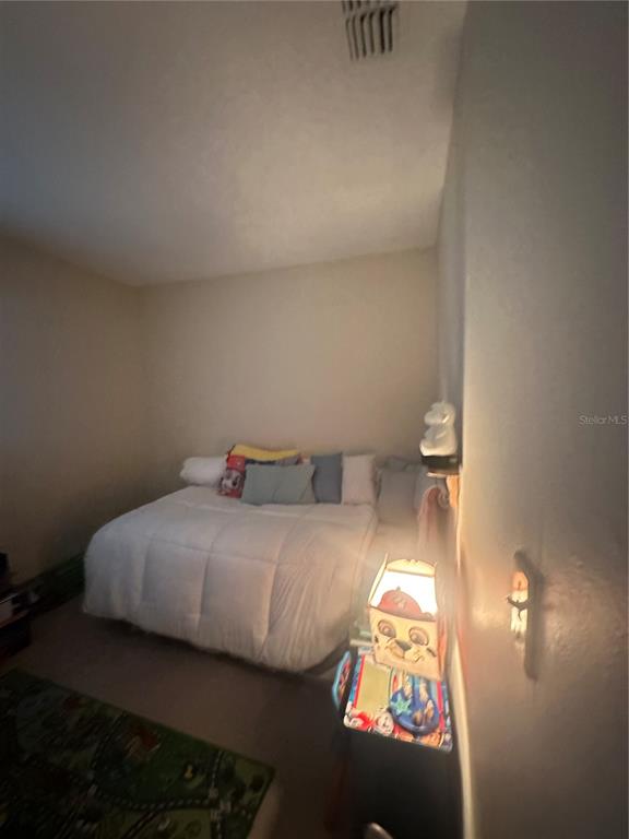 8440 Old Post Road, Unit 202 Port Richey, FL 34668 - Photo 10 of 17 a bedroom with a bed and a night stand