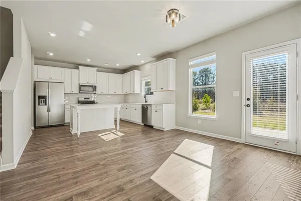 a view of kitchen with wooden floor and electronic appliances