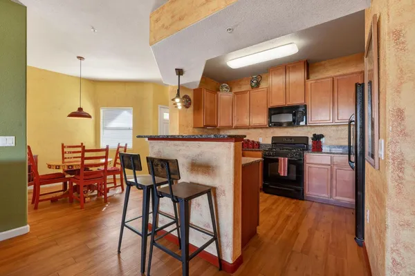 a kitchen with stainless steel appliances a table chairs refrigerator and cabinets