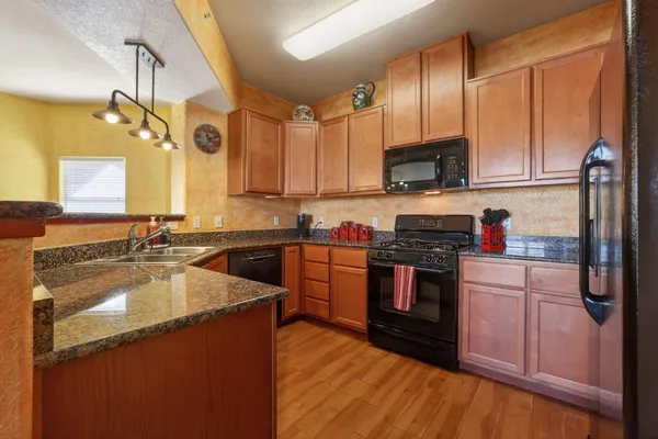 a kitchen with stainless steel appliances granite countertop a sink stove and refrigerator