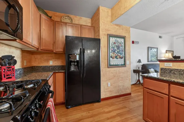 a kitchen with stainless steel appliances granite countertop a refrigerator stove and sink