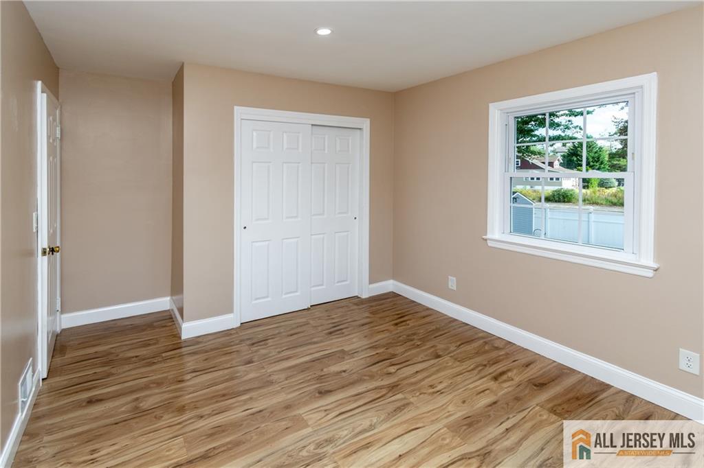24 Old New Brunswick Road Piscataway, NJ 08854 - Photo 13 of 27 a view of an empty room with wooden floor and a window