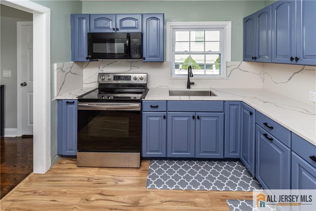 24 Old New Brunswick Road Piscataway, NJ 08854 - Photo 6 of 27 a kitchen with stainless steel appliances a stove a sink and a microwave
