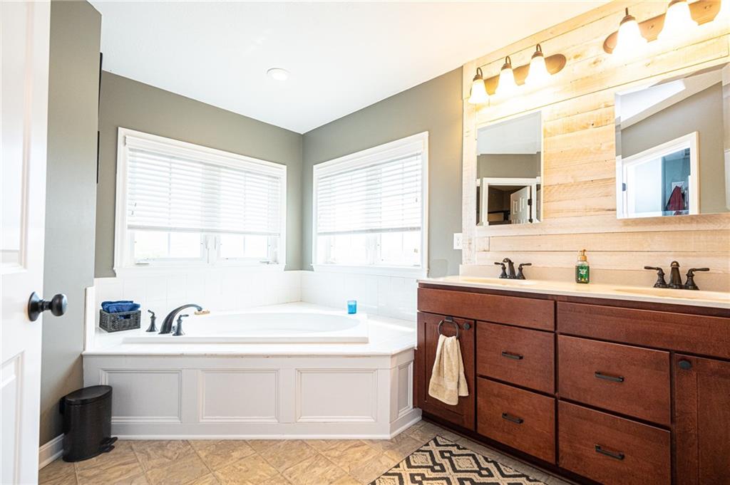 132 Granite Ridge Circle Mars, PA 16046 - Photo 18 of 25 Master bath features a double bowl vanity, wood plank feature wall, and a relaxing soaking tub!