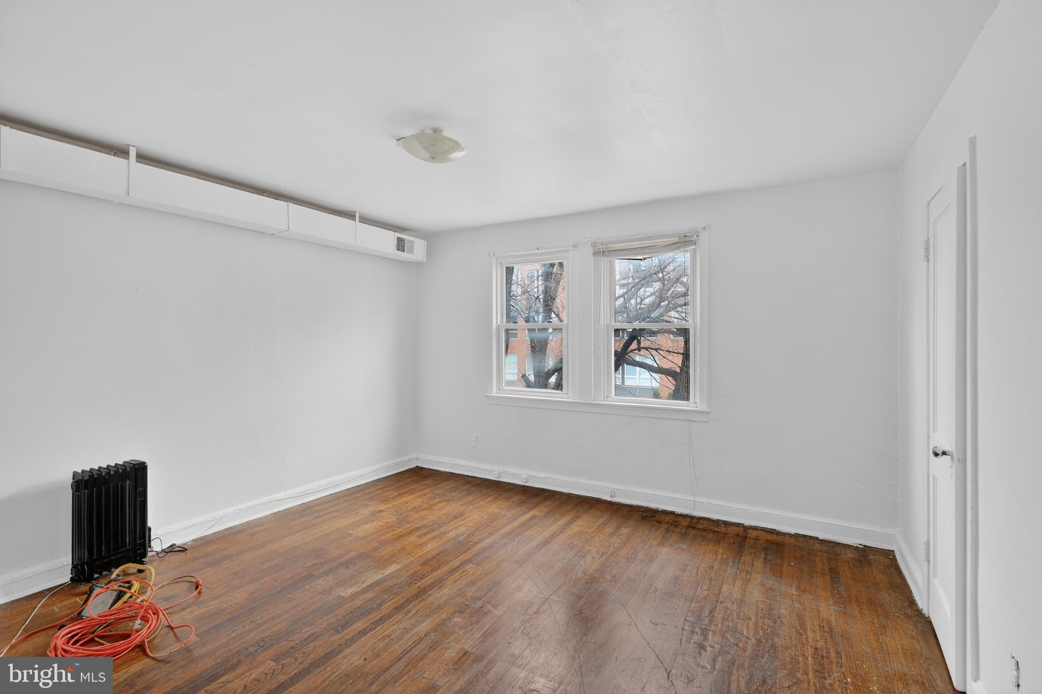 1711 H Street Northeast Washington, DC 20002 - Photo 7 of 15 a view of an empty room with wooden floor and a window