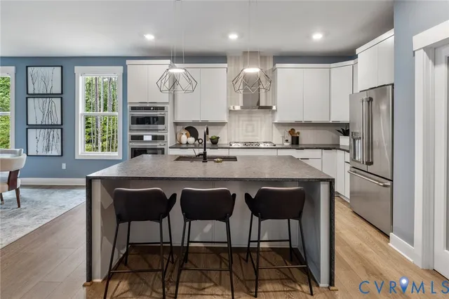 a kitchen with granite countertop a sink and a refrigerator