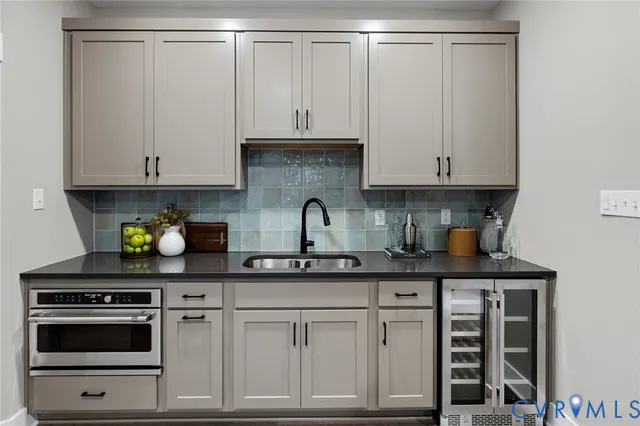 a kitchen with stainless steel appliances granite countertop a sink and a white cabinets