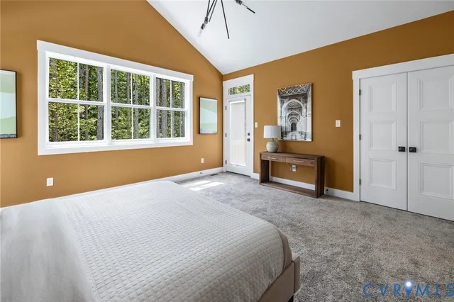 a spacious bedroom with a large bed closet and window